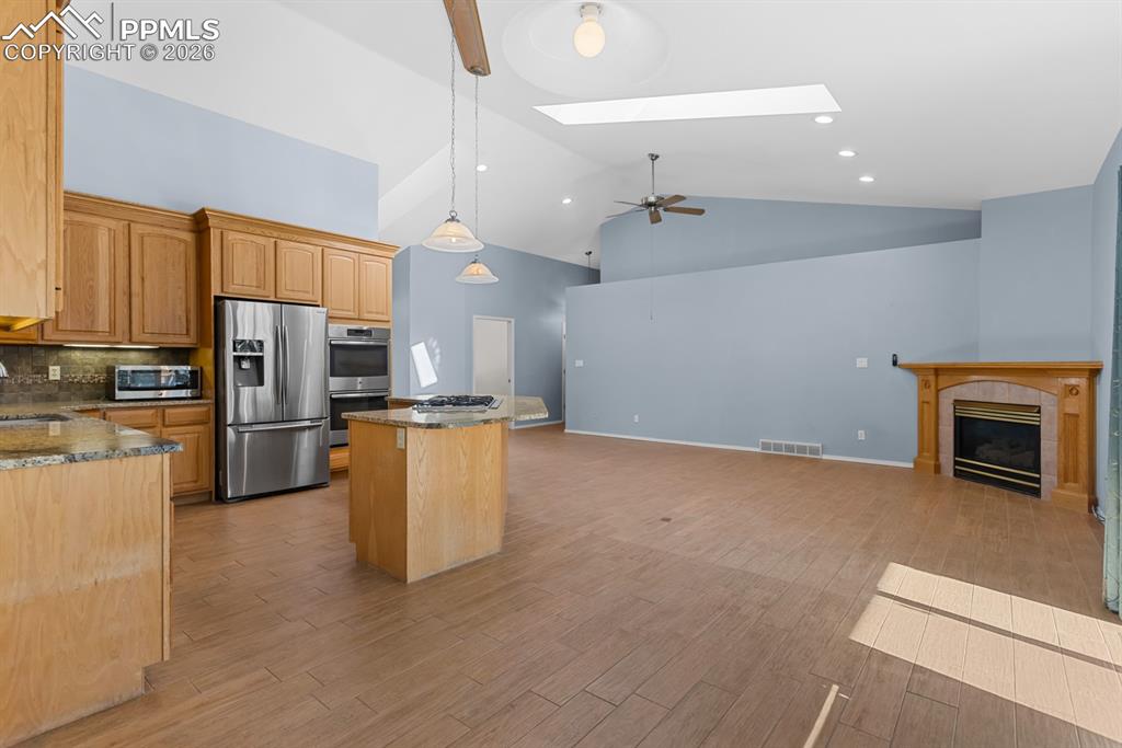 Image 21 of 50: Living room with walkout to the easy maintenance deck and a gas fireplace