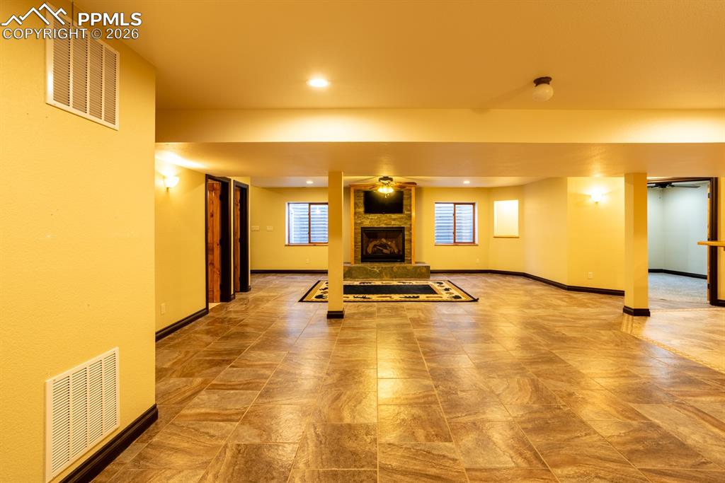 Image 35 of 50: Basement family room, gas fireplace