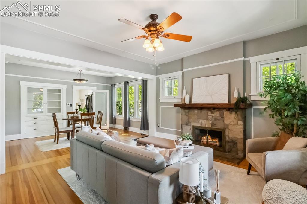 Image 2 of 49: Open-concept living with stone fireplace centerpiece