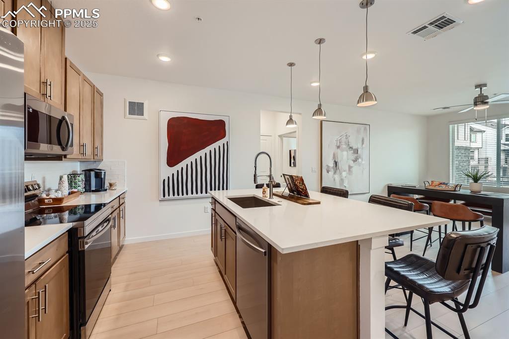 Image 4 of 9: Kitchen with stainless steel appliances, recessed lighting, light counterto
