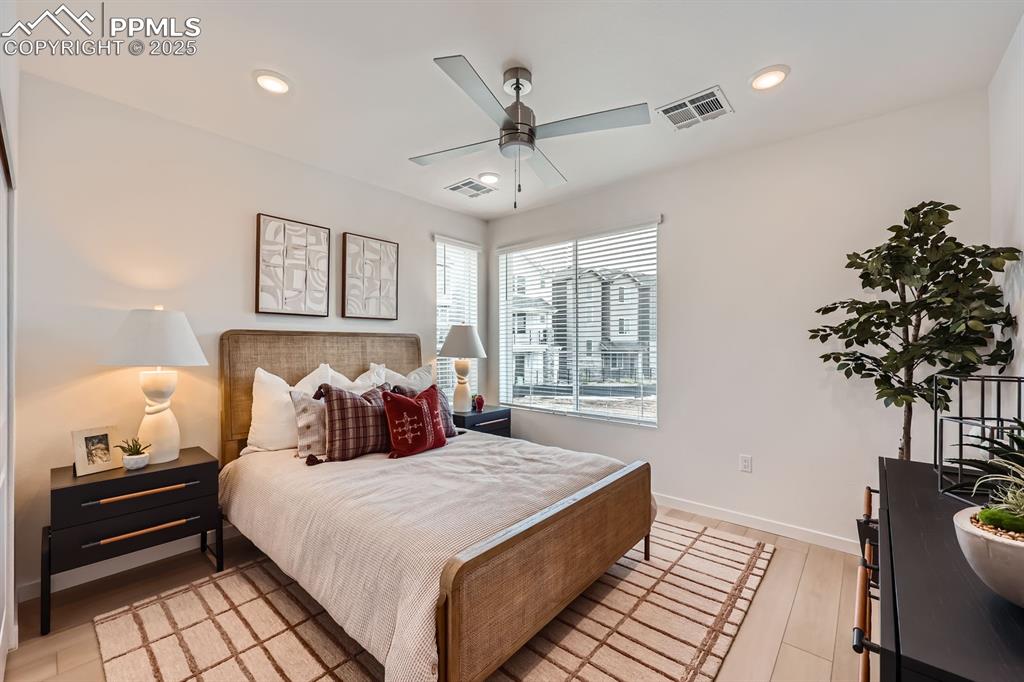 Image 5 of 9: Bedroom with light wood finished floors, recessed lighting, and ceiling fan
