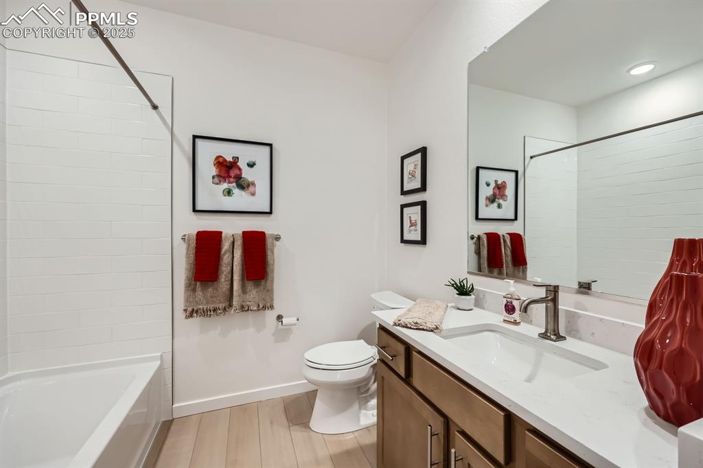 Image 8 of 9: Bathroom with vanity, wood finished floors, and shower / bath combination