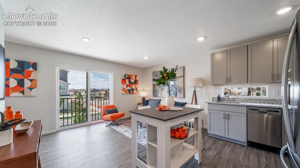 Image 10 of 26: Open-concept living space featuring wood-finish flooring, recessed lighting