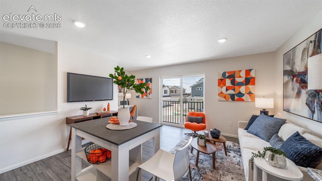 Image 14 of 26: Open-concept living area featuring wood-finish flooring and recessed lighti