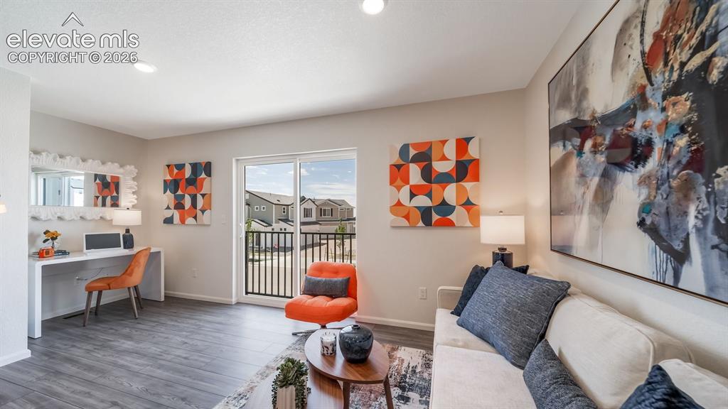 Image 15 of 26: Spacious room featuring wood-finish flooring, recessed lighting, and a slid