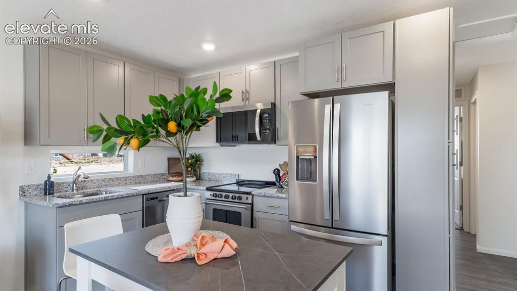 Image 9 of 26: Modern kitchen featuring light gray cabinetry, stainless steel appliances,
