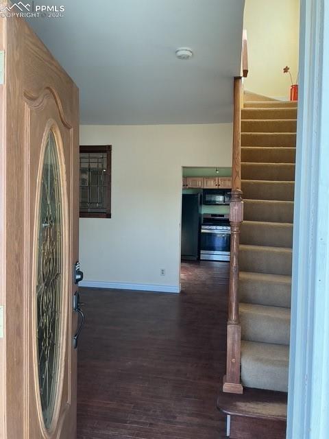 Image 13 of 36: Entrance foyer with dark wood-style floors and stairs