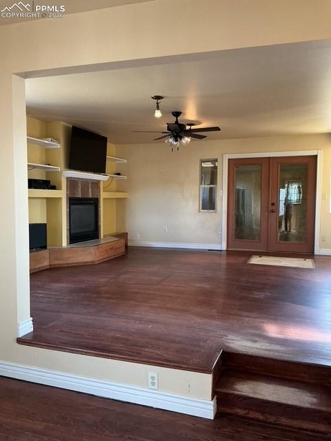 Image 18 of 36: Unfurnished living room with dark wood finished floors, built in shelves, a