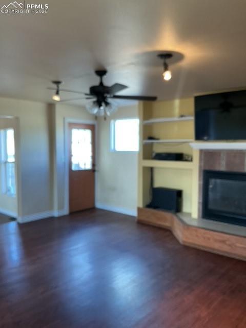 Image 19 of 36: Unfurnished living room featuring built in features, a glass covered firepl