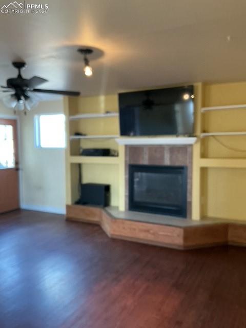 Image 20 of 36: Unfurnished living room featuring a ceiling fan, built in shelves, a glass