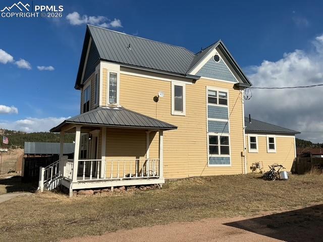 Image 6 of 36: Rear view of house featuring a metal roof