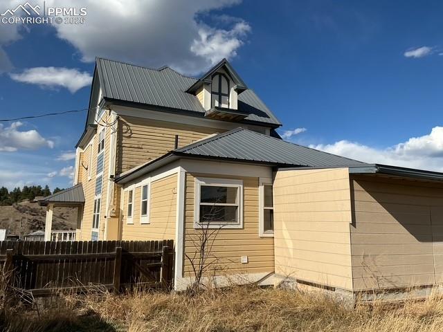 Image 8 of 36: View of side of property with crawl space and a metal roof
