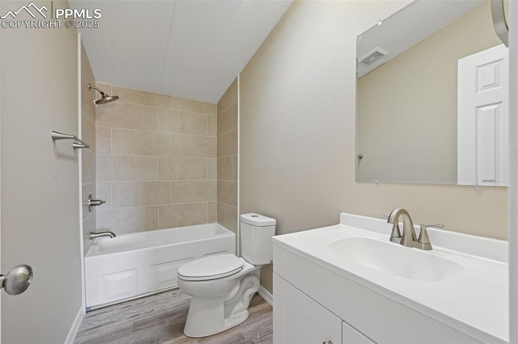 Image 13 of 33: Bathroom with vanity, shower / bath combination, and light wood finished fl