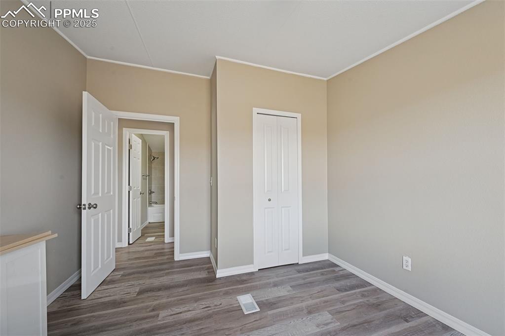 Image 14 of 33: Unfurnished bedroom with wood finished floors and a closet