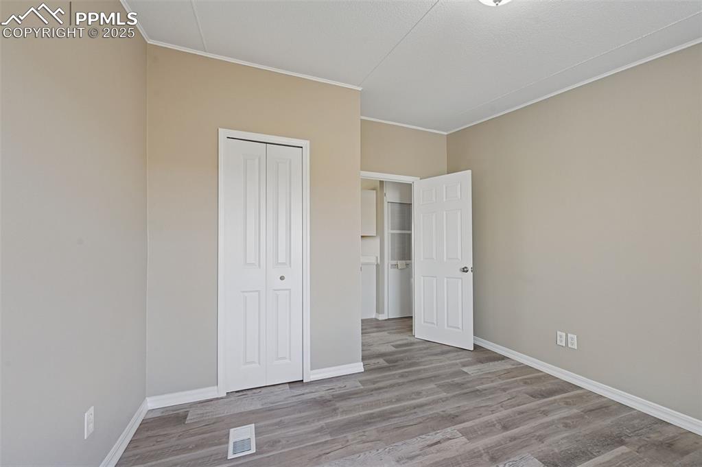 Image 15 of 33: Unfurnished bedroom featuring light wood finished floors, a closet, and orn