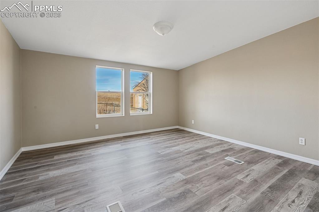 Image 23 of 33: Empty room featuring light wood-style floors and baseboards