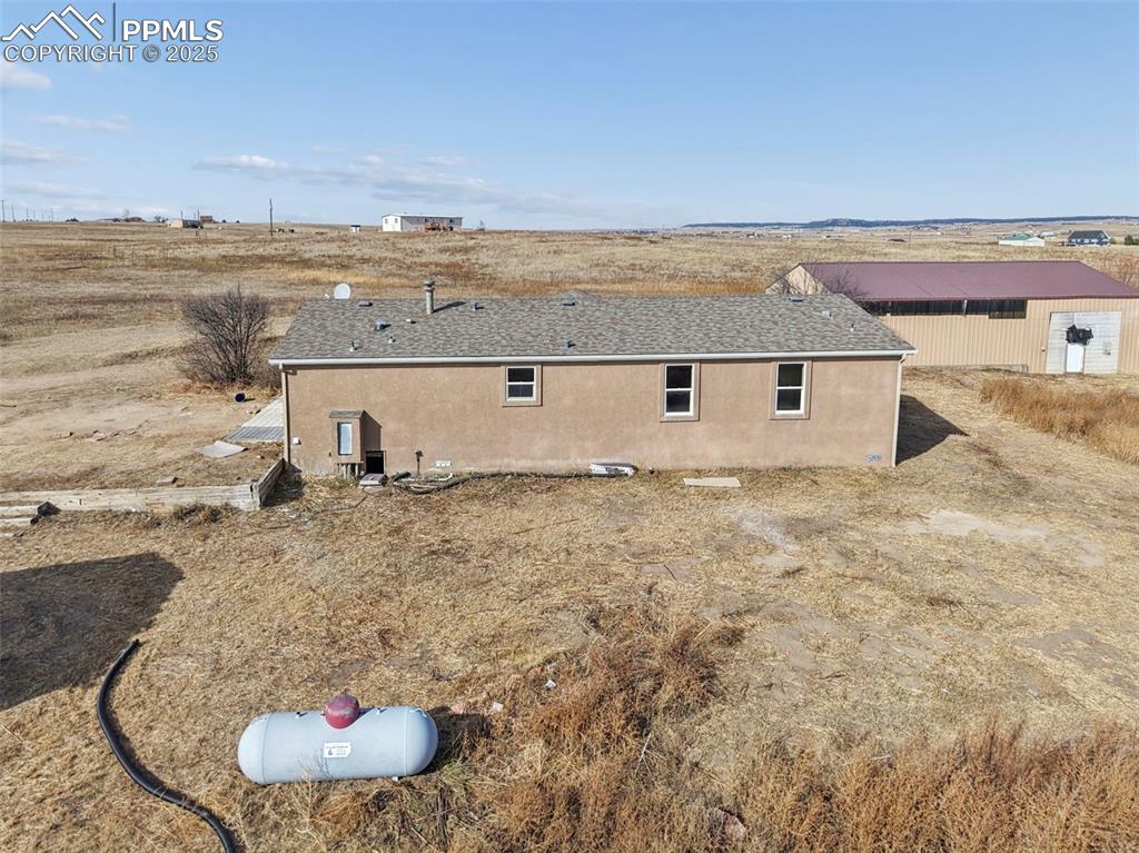 Image 3 of 33: Back of house featuring roof with shingles and stucco siding
