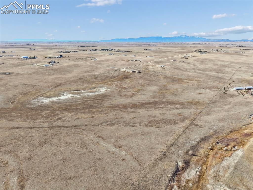 Image 32 of 33: View of rural area with a desert landscape and a mountainous background