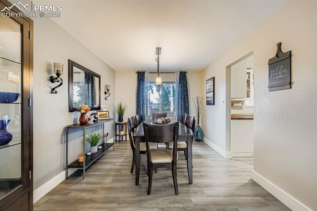 Image 11 of 27: Dining area featuring light wood-style floors and a textured wall