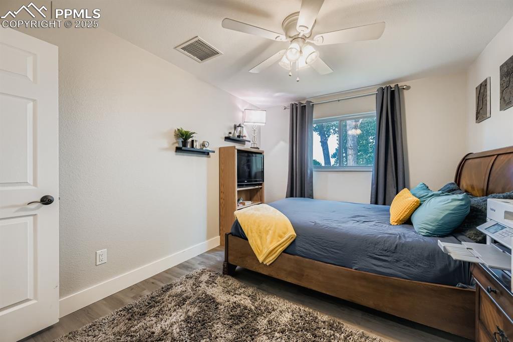 Image 18 of 27: Bedroom featuring dark wood finished floors and ceiling fan