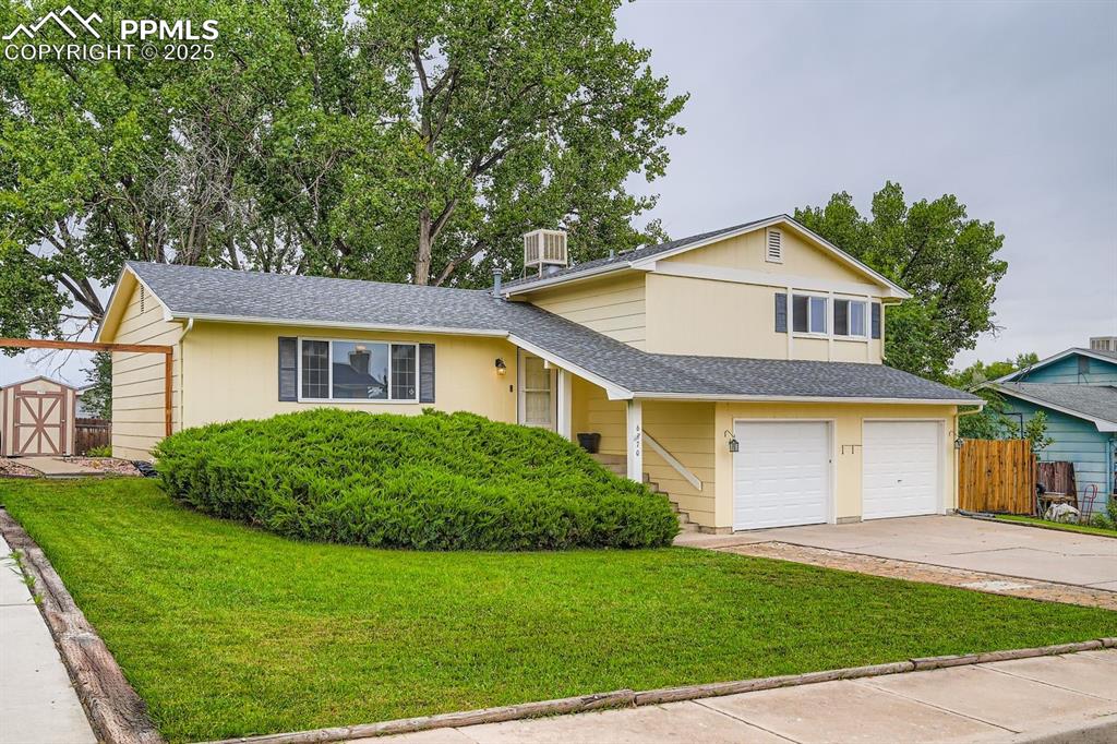 Image 2 of 27: View of front facade featuring a shingled roof, a garage, and concrete driv