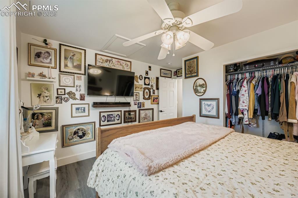 Image 20 of 27: Bedroom featuring attic access, dark wood finished floors, a closet, and a