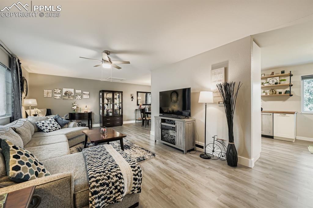 Image 5 of 27: Living room with a ceiling fan and light wood-type flooring