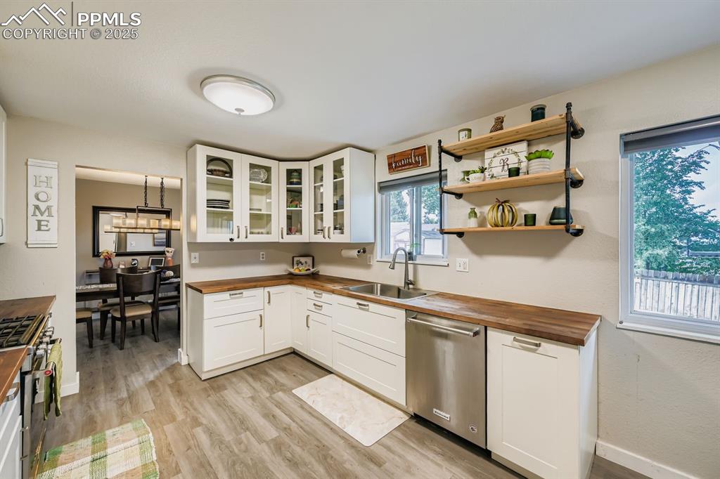 Image 7 of 27: Kitchen with wood counters, white cabinets, stainless steel appliances, and
