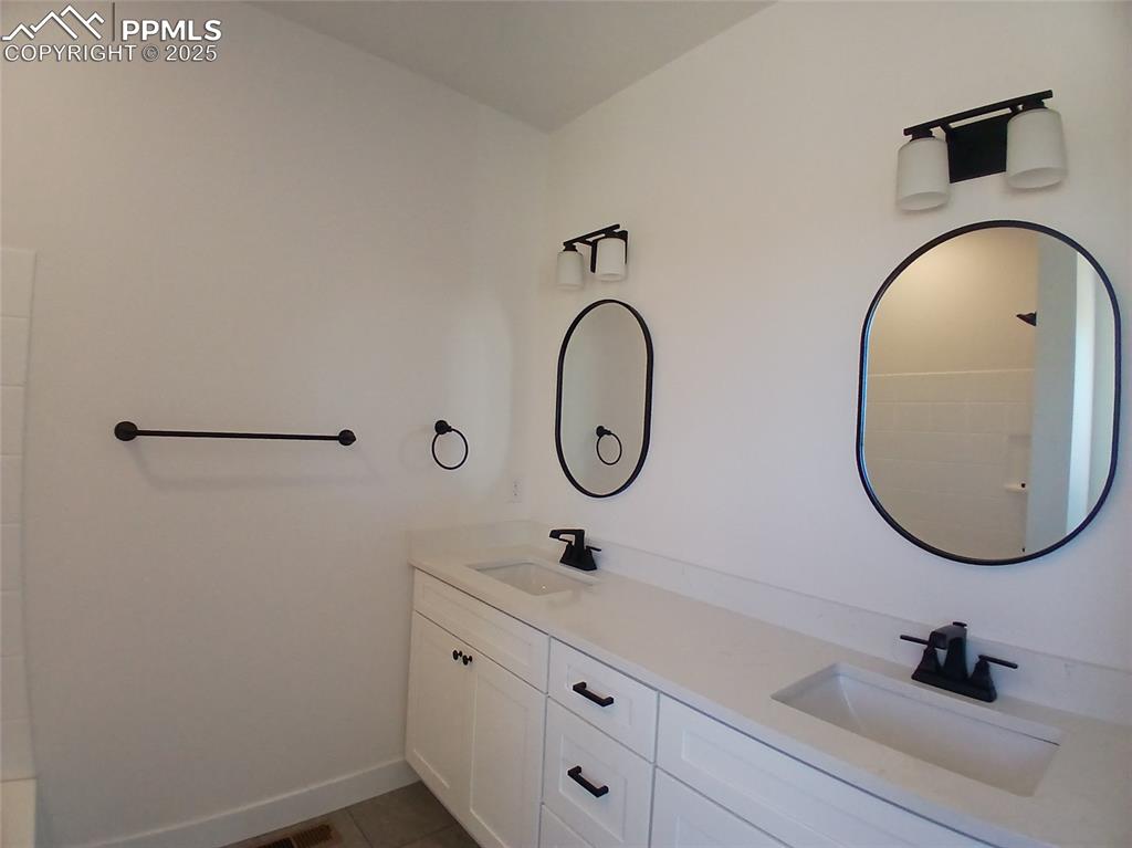 Image 22 of 39: Double sinks, quartz countertop & tile floor. flooring.
