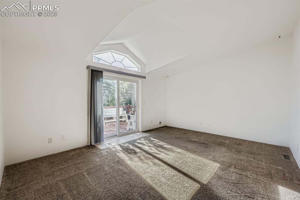 Image 13 of 29: Carpeted empty room featuring high vaulted ceiling