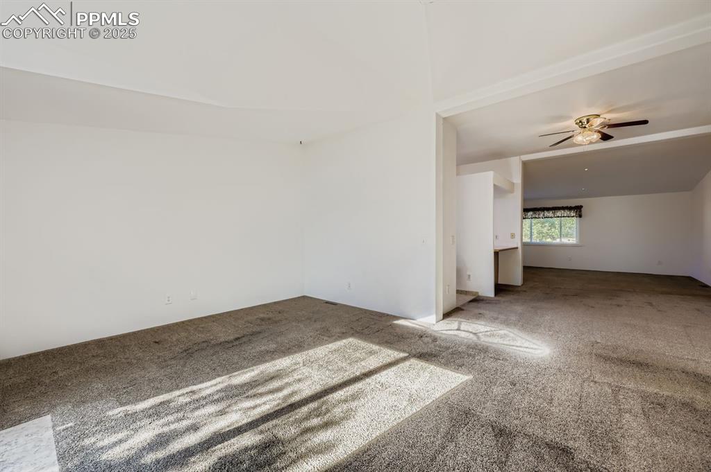Image 14 of 29: Carpeted spare room with ceiling fan