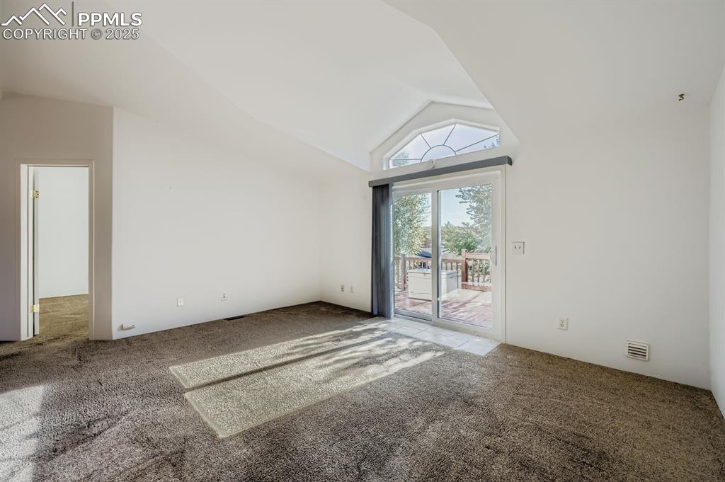Image 15 of 29: Carpeted empty room featuring high vaulted ceiling