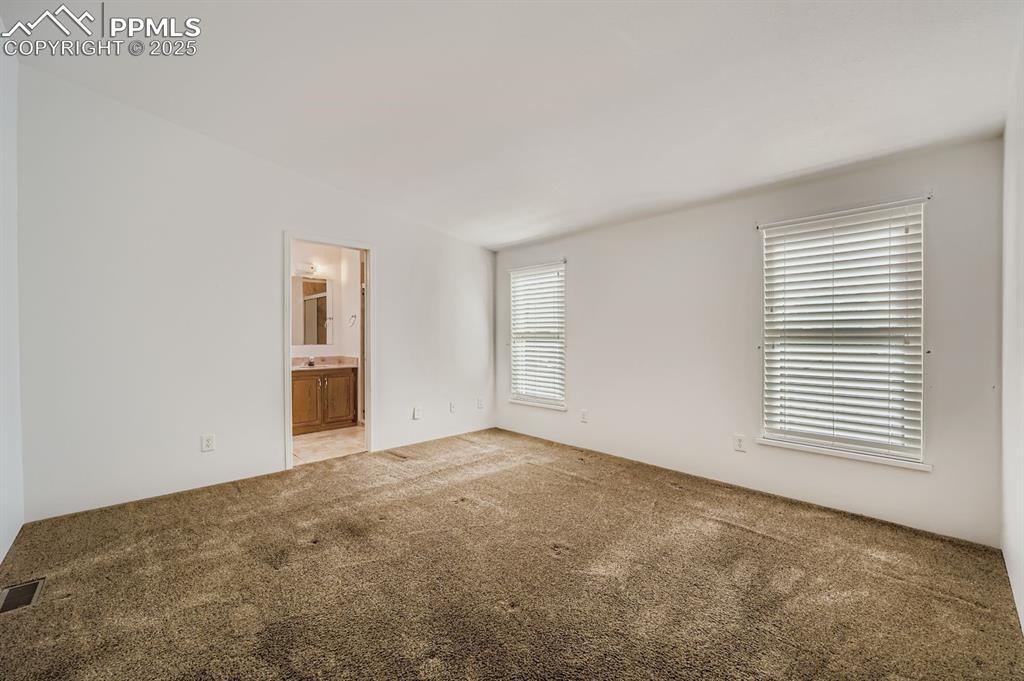 Image 16 of 29: Unfurnished bedroom with carpet and ensuite bath