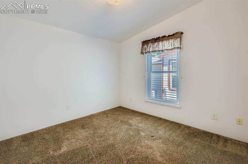 Image 23 of 29: Carpeted empty room featuring lofted ceiling