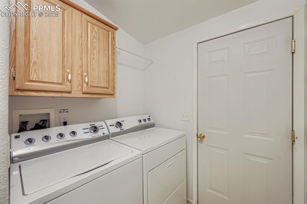 Image 27 of 29: Laundry room with cabinet space and washing machine and clothes dryer