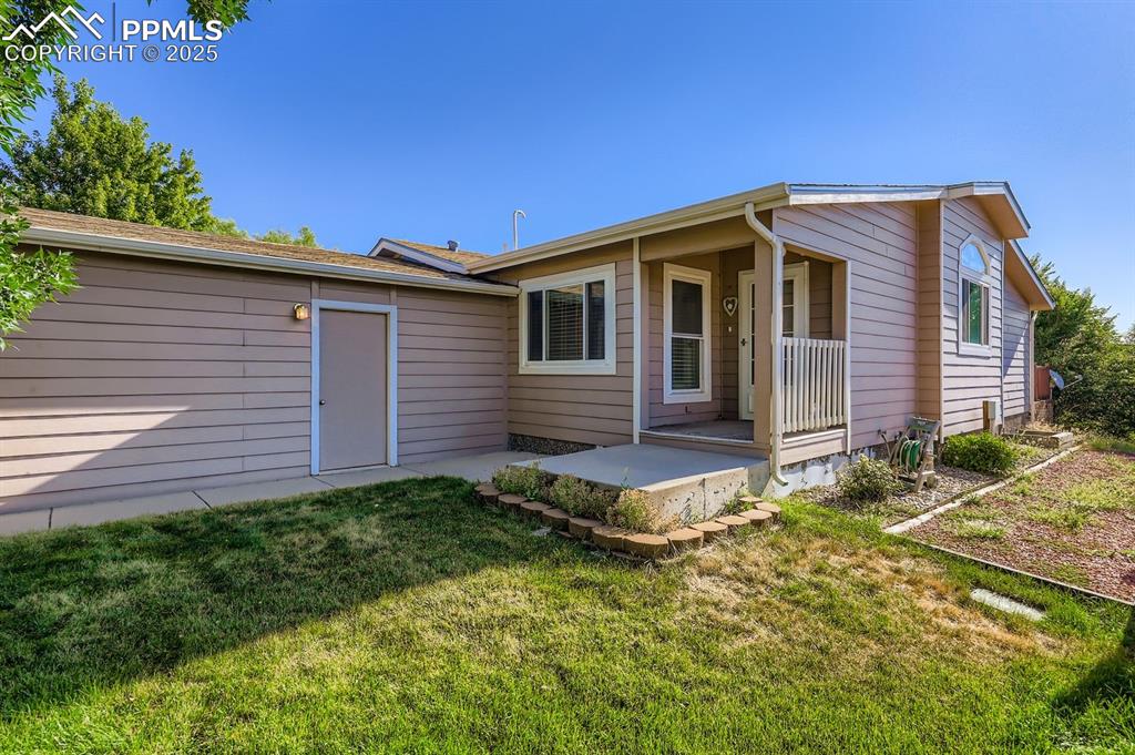 Image 4 of 29: Back of house featuring a yard and a porch