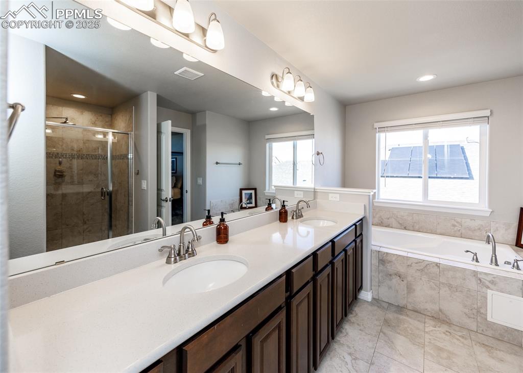 Image 20 of 43: Primary bathroom with double vanity sunken tub and separate shower.