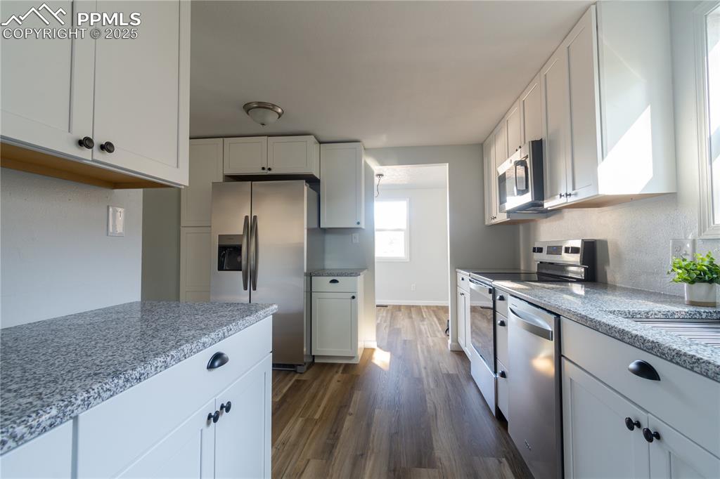 Image 12 of 37: Kitchen featuring appliances with stainless steel finishes, dark wood-type 