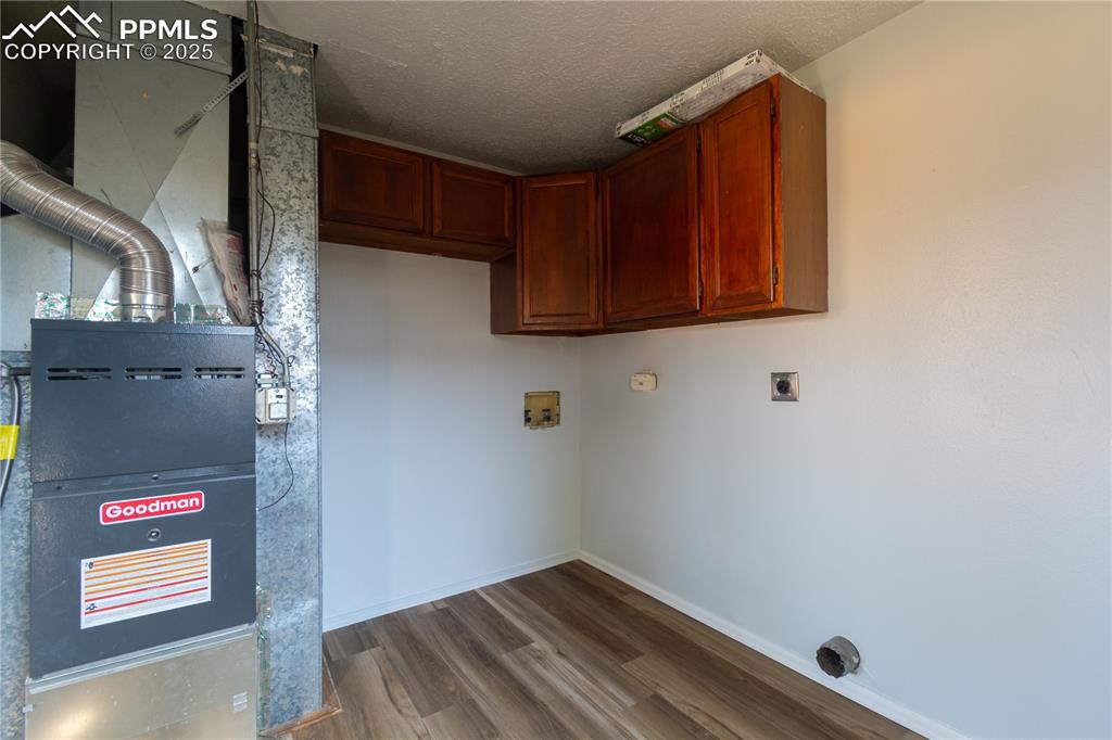 Image 20 of 37: Laundry area with  wood-style flooring, heating unit, washer hookup, electr