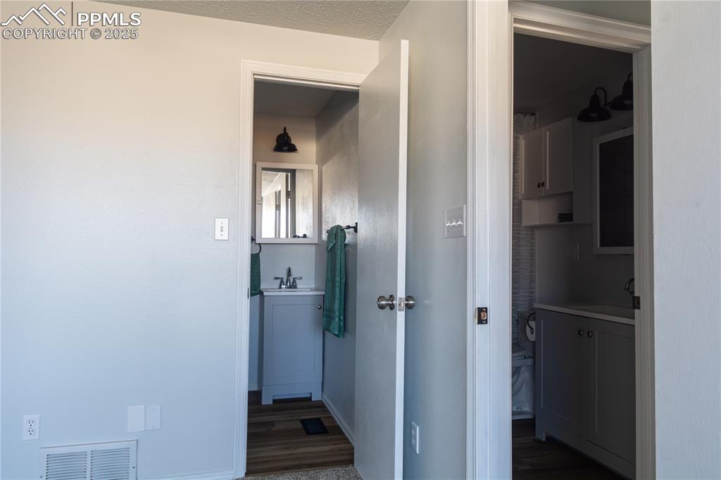 Image 24 of 37: Hall featuring dark wood-style floors and a textured ceiling