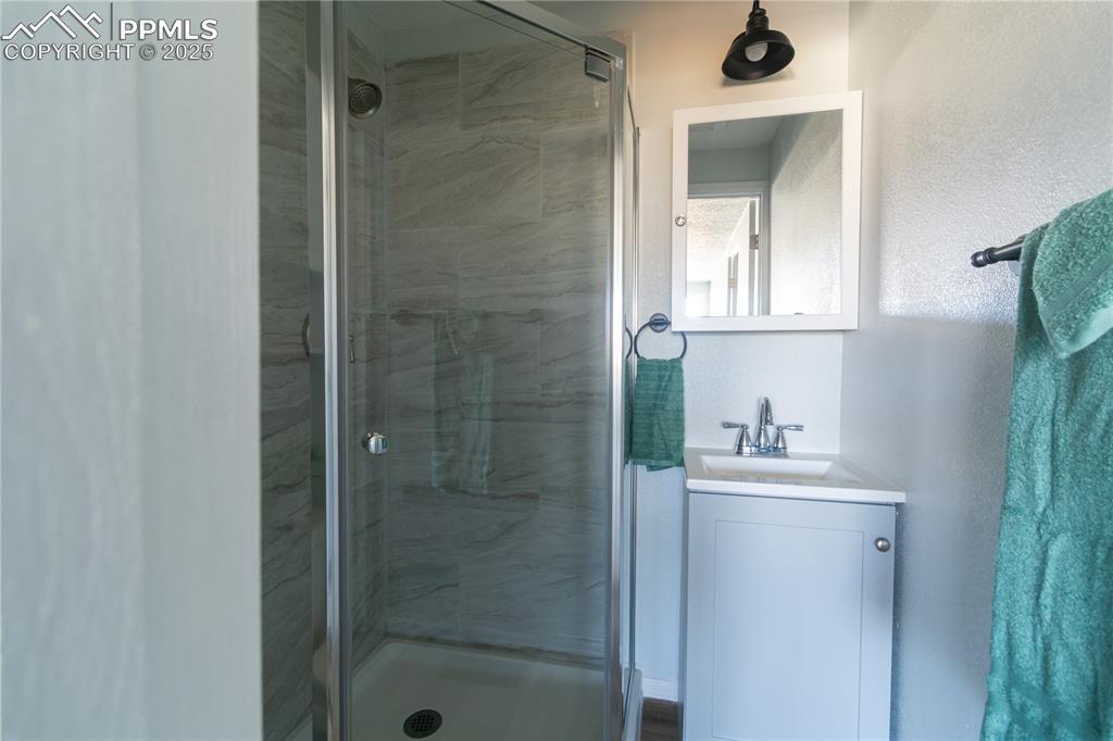 Image 25 of 37: Bathroom with a stall shower and vanity