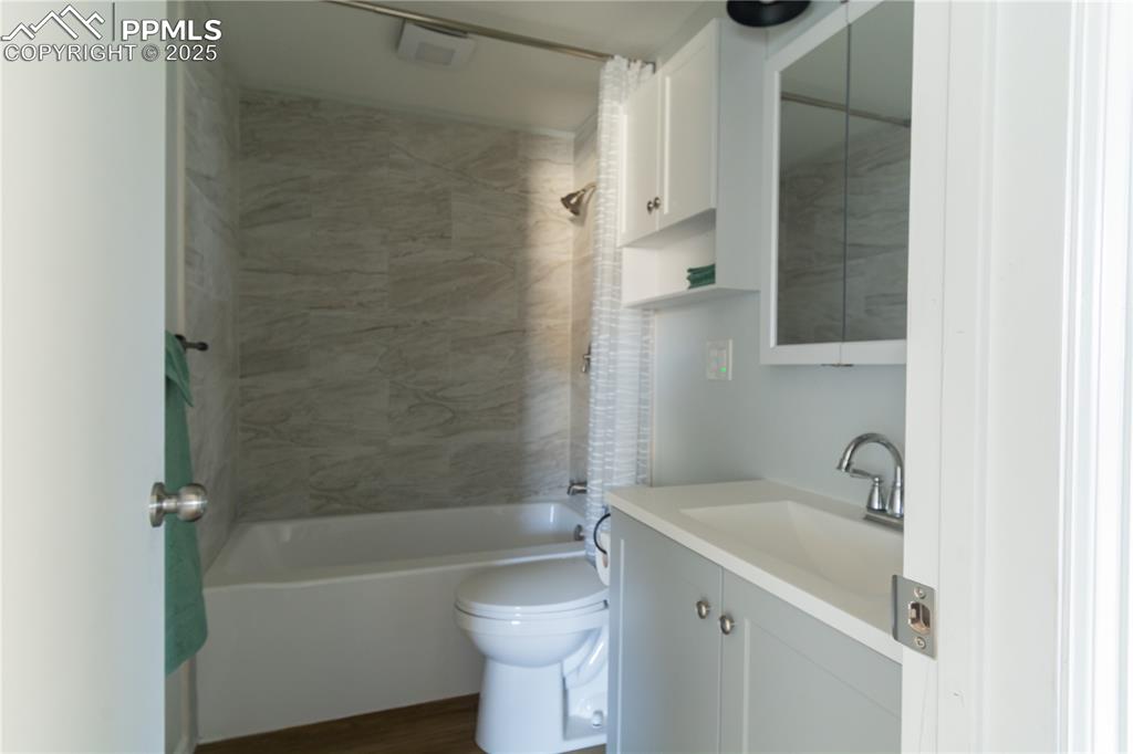 Image 28 of 37: Full bathroom featuring shower / bathtub combination with curtain, vanity, 