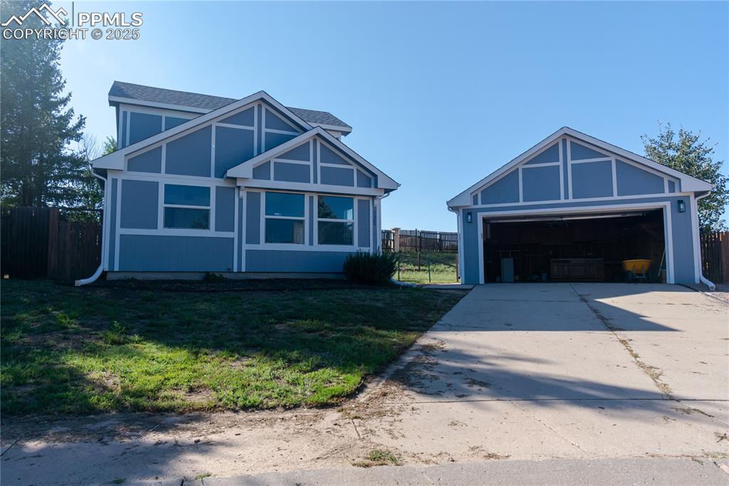 Image 3 of 37: View of front of house with an outbuilding, a garage, and concrete driveway