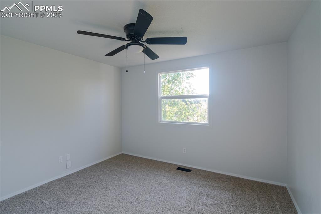 Image 31 of 37: Carpeted spare room with baseboards and ceiling fan