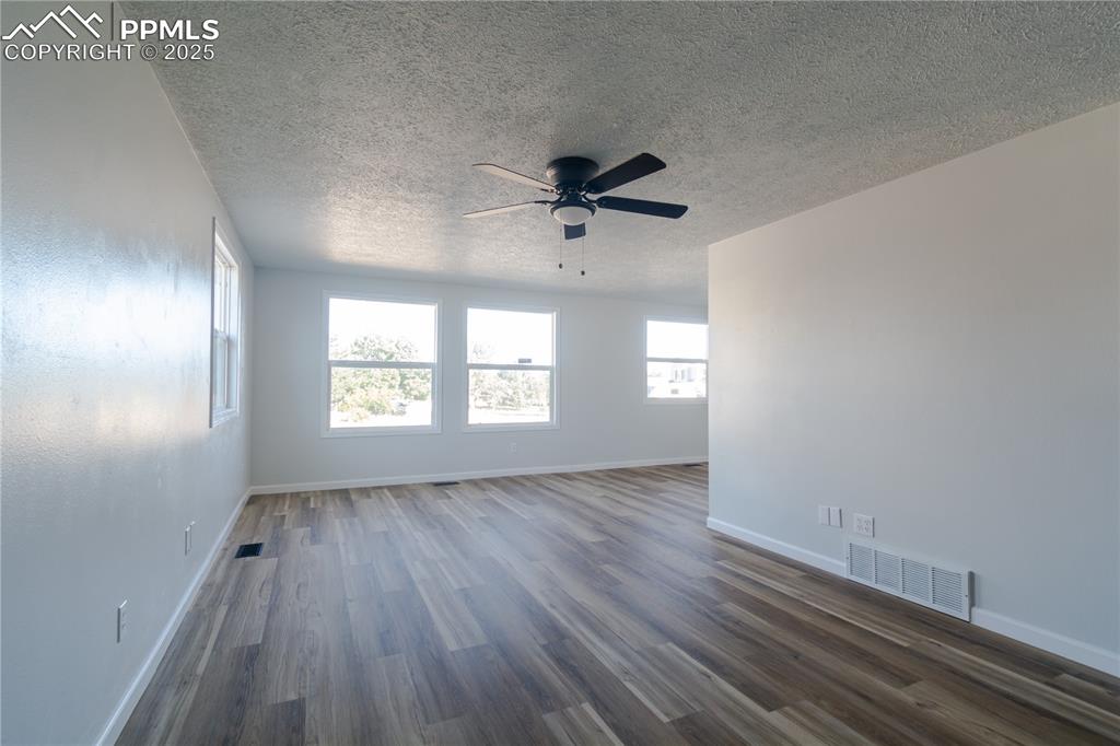 Image 7 of 37: Spare room featuring healthy amount of natural light, dark wood-style floor