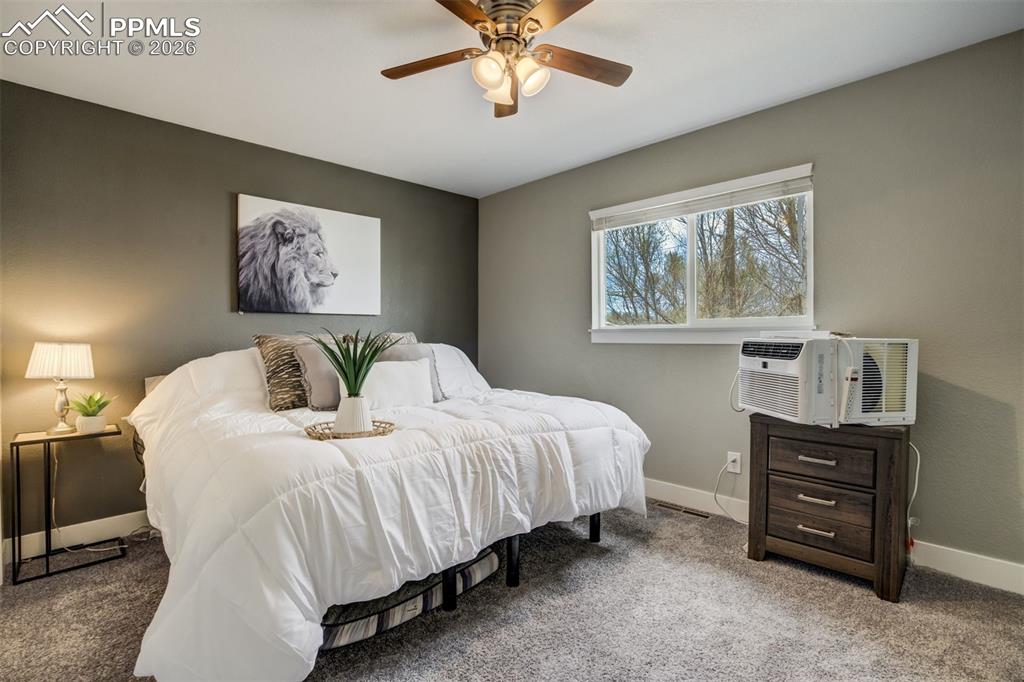 Image 16 of 29: Bedroom with carpet flooring, a ceiling fan, and cooling unit