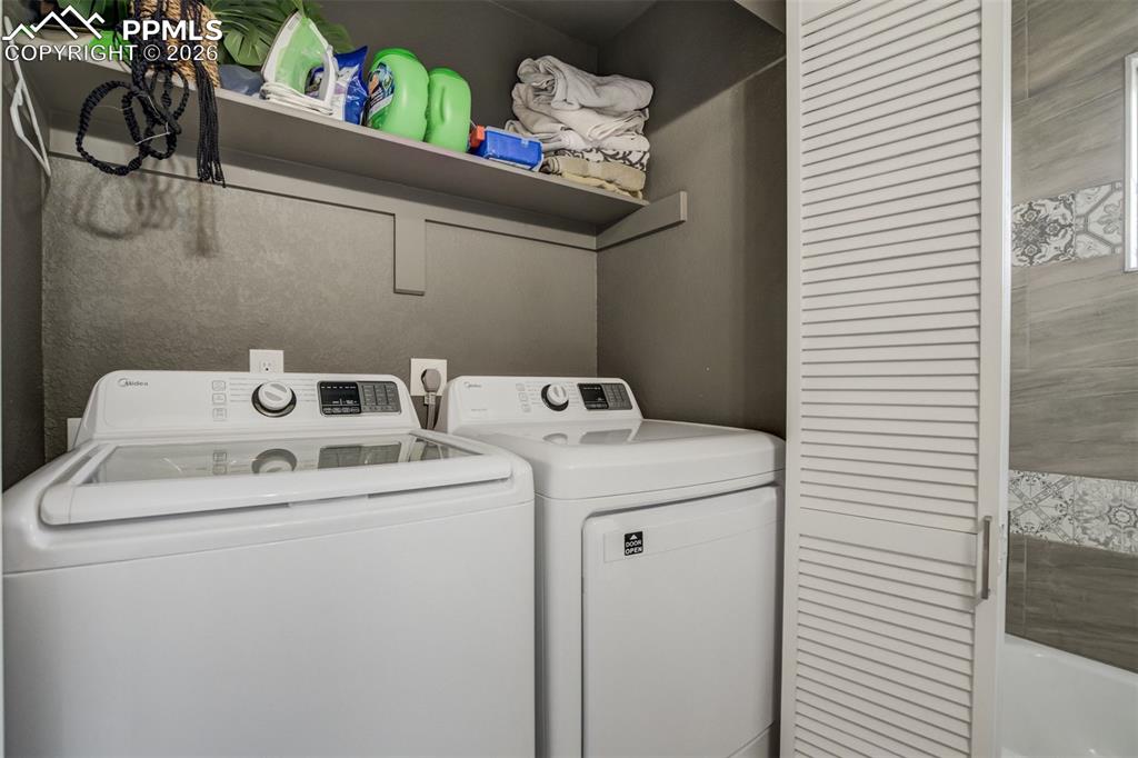 Image 23 of 29: Laundry room with washer and clothes dryer