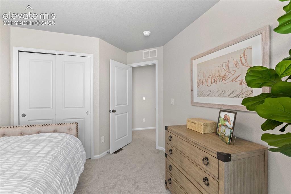 Image 22 of 25: Serene primary bedroom featuring neutral wall finishes, carpeted flooring, 