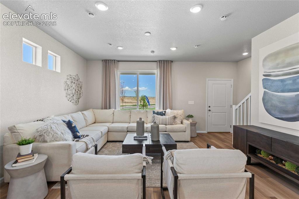Image 3 of 25: Recessed ceiling lighting, wood-finish flooring, a large window, and white 