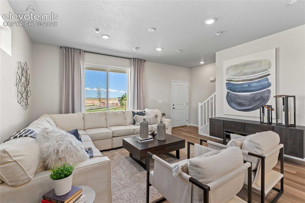 Image 5 of 25: Bright and open living area featuring a neutral color palette, large window